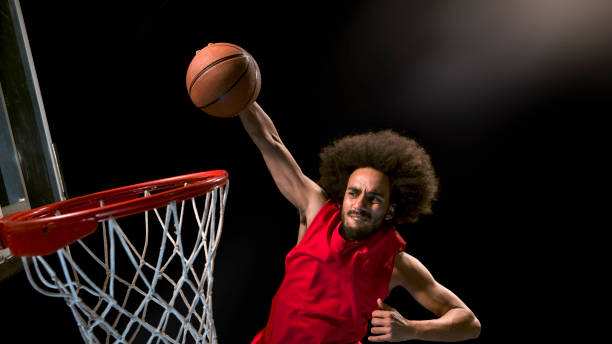 istock Male basketball player doing slam dunk 946017102