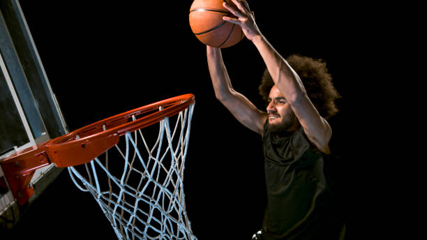 istock Male basketball player doing slam dunk 946017112