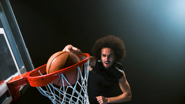 istock Male basketball player doing slam dunk 946017116