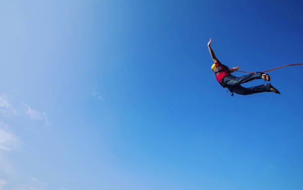 Jump off a cliff into a canyon with a rope. Jump off a cliff into a canyon with a rope. bungee jumping stock pictures, royalty-free photos & images