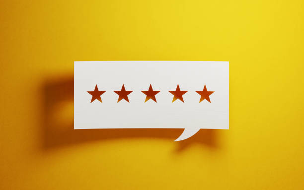 istock Feedback Concept - White Chat Bubble With Cut Out Star Shapes Over Yellow Background 946021544
