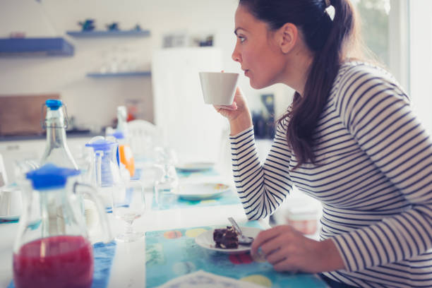 istock Young woman having breakfast in her kitchen 946022034