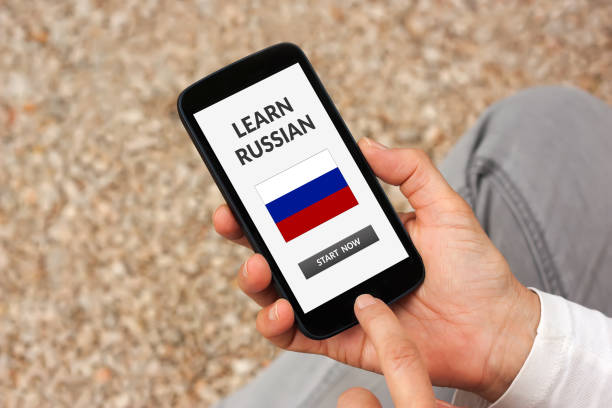 istock Hands holding smart phone with learn Russian concept on screen 946022080