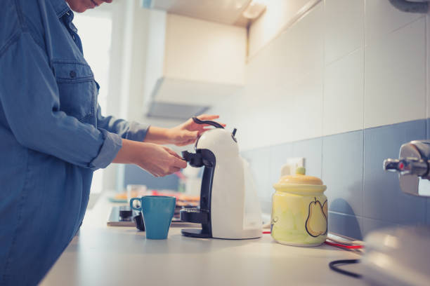 istock Young woman making morning coffee in her kitchen 946022094