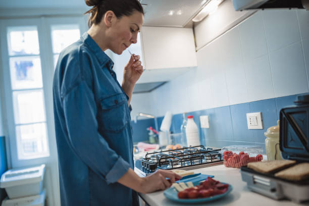 istock Young woman having breakfast in her kitchen 946022148