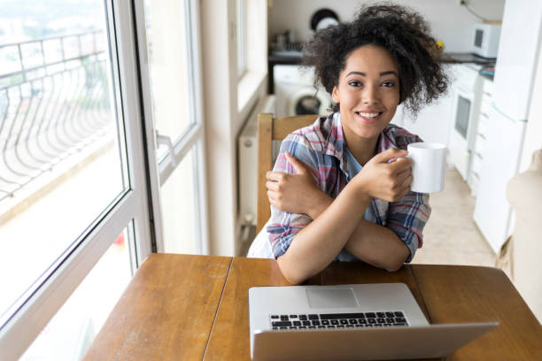 istock Woman drinking coffee and using laptop at home 946024822