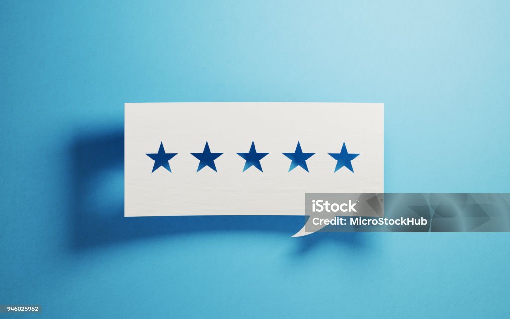 Concetto di feedback - Bolla di chat bianca con forme di stelle ritagliate su sfondo blu - Foto stock royalty-free di Valutazione