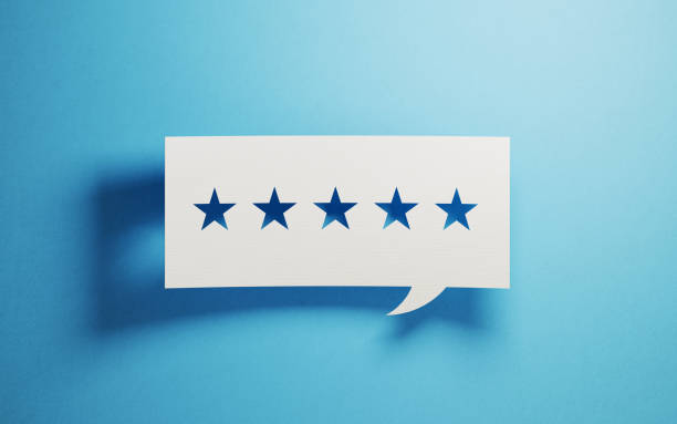 istock Feedback Concept - White Chat Bubble With Cut Out Star Shapes Over Blue Background 946025962