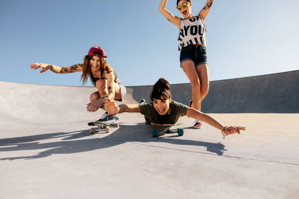 istock Women riding skateboards and having fun at skate park 946032620