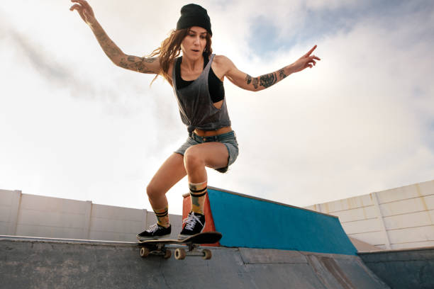 istock Cool young woman skateboarding at skate park 946032746