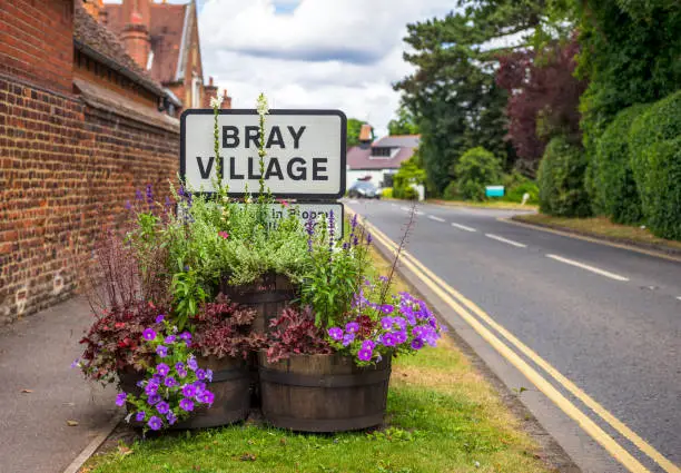 Flowers around a sign at the entrance to the village of Bray in the English county of Berkshire.