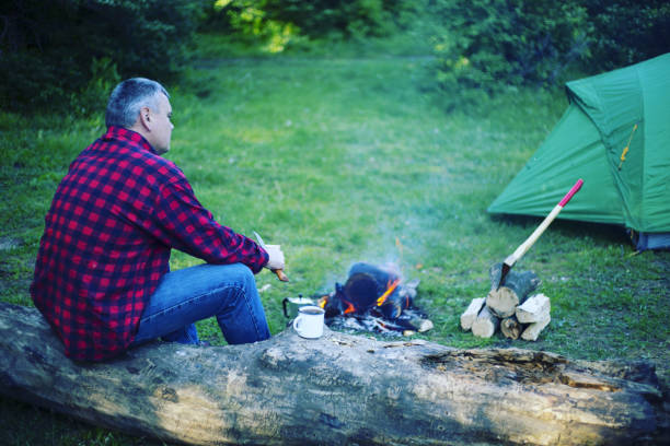 istock A man is preparing breakfast at a fire in the camp. 946039422