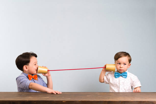 Two childeren are using paper cups as a telephone Two childeren are using paper cups as a telephone toy phone stock pictures, royalty-free photos & images