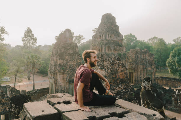 homem sentado no templo de angkor, no camboja - cambodia monk buddhism angkor wat - fotografias e filmes do acervo