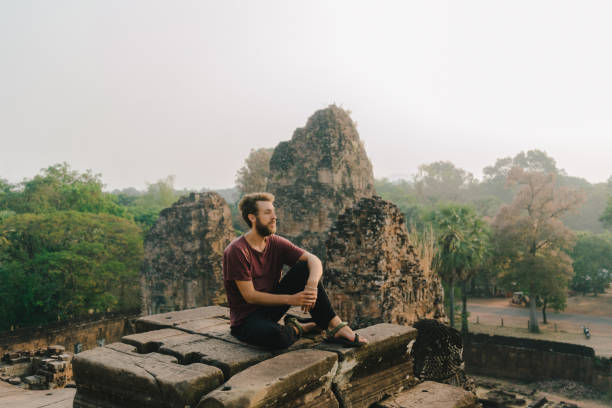 istock Man sitting  in Angkor Temple in Cambodia 946040226