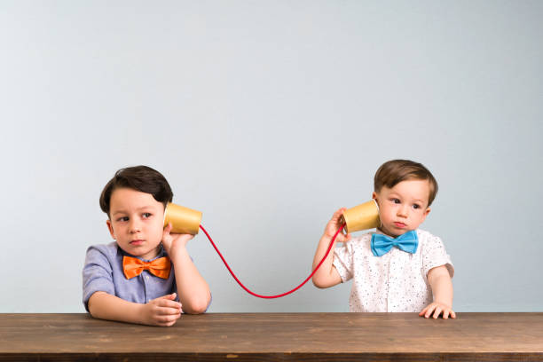 Two childeren are using paper cups as a telephone Two childeren are using paper cups as a telephone toy phone stock pictures, royalty-free photos & images