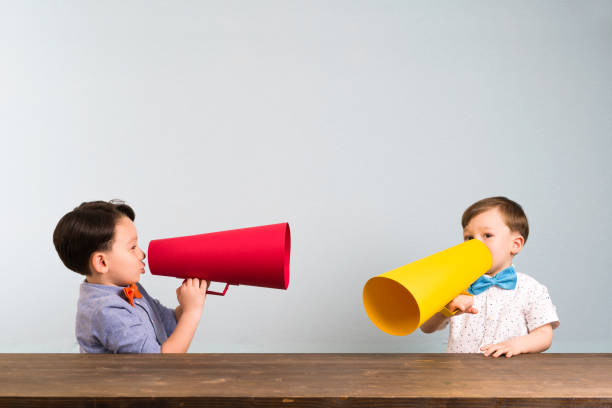 istock Two children are talking with paper megaphone 946042604