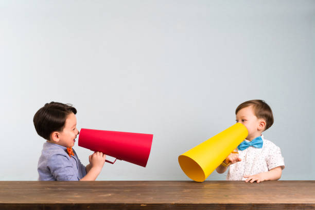 istock Two children are talking with paper megaphone 946042606