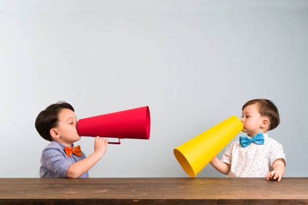 istock Two children are talking with paper megaphone 946042862