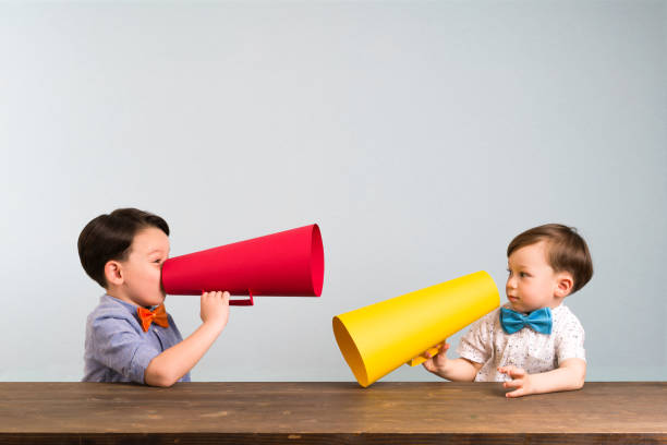 istock Two children are talking with paper megaphone 946042870