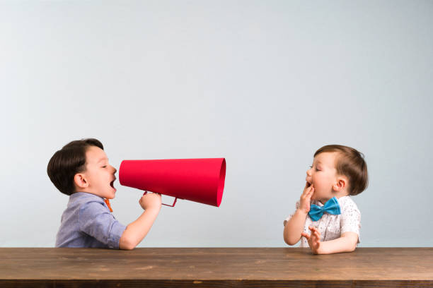 istock Child is shouting through megaphone to another child 946043110