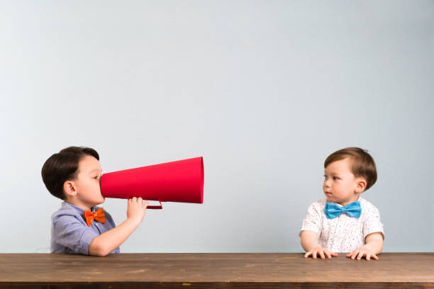 istock Child is shouting through megaphone to another child 946043242