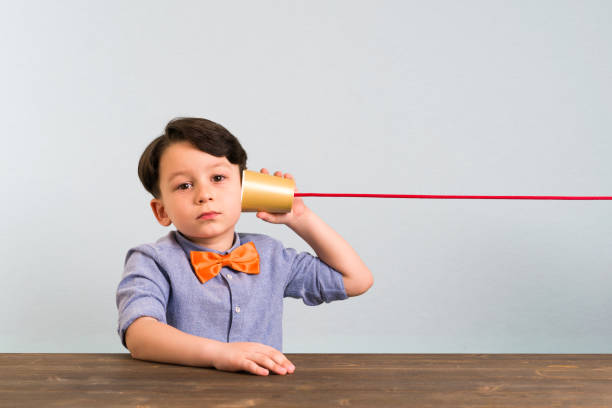 istock The child is using paper cup as a telephone 946043728