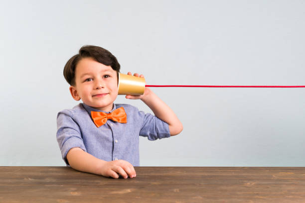 istock The child is using paper cup as a telephone 946043750