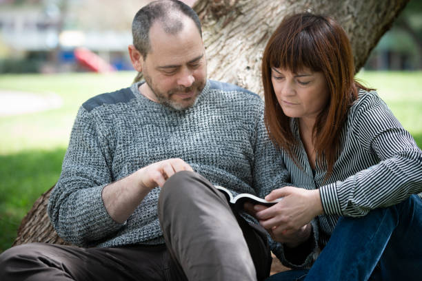 istock Serene couple reading in a park 946044184