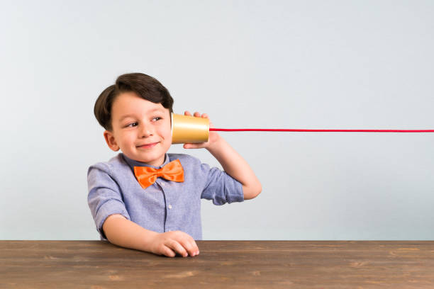 The child is using paper cup as a telephone The child is using paper cup as a telephone toy phone stock pictures, royalty-free photos & images