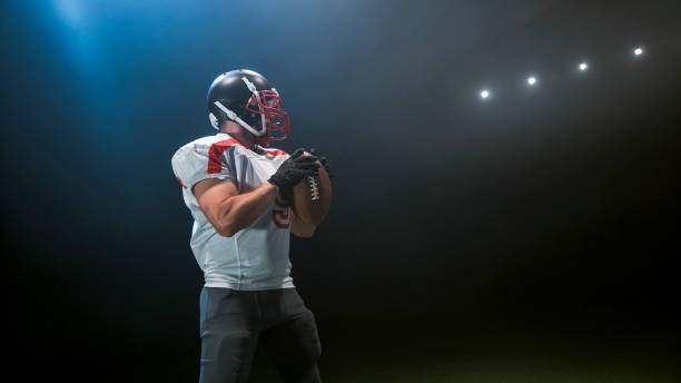 istock American football player holding ball 946046382