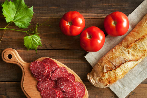 istock salami, tomatoes and baguette on a wooden table 946046658