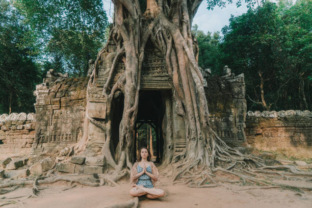 istock Woman doing yoga in   Angkor  temple 946046942