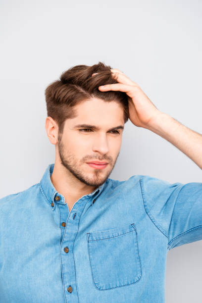 istock Handsome man touching his hair isolated on gray background 946048140