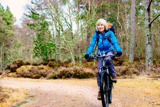 istock Senior woman cycling on a forest trail 946048570