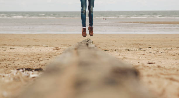 istock Low Section Of Woman Jumping On Beach 946055156