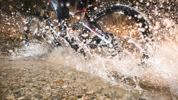 istock Mountain biker riding mountain bike through water 946060554