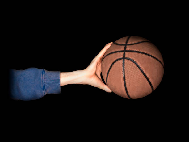 istock hand palming basketball close up in dark studio 946087348