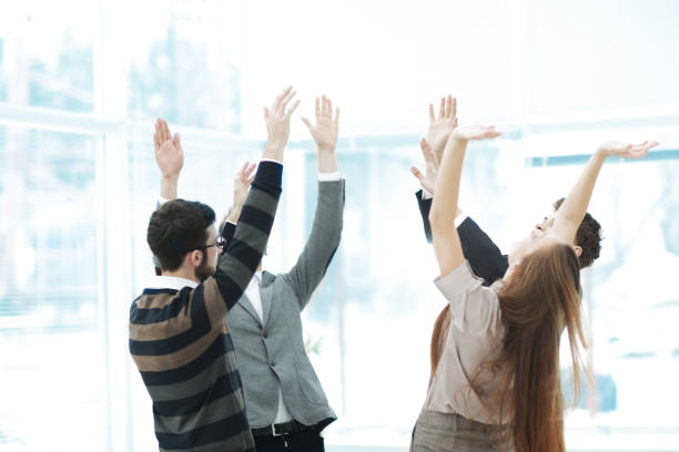 istock Motivated young business team pledging support raising their hands 946117442