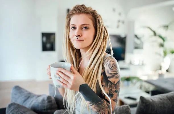 Portrait of young tattooed woman with blond hairs