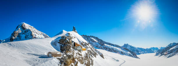 alps snowy sunburst over jungfraujoch mountain peaks panorama switzerland - jungfraujoch imagens e fotografias de stock