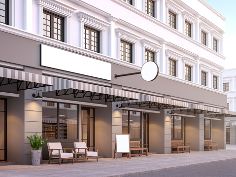 Front of classical style commercial building 3d render.There are a street shop, The building has classical style with gray and white color. The shop has white blank sign with clipping path.