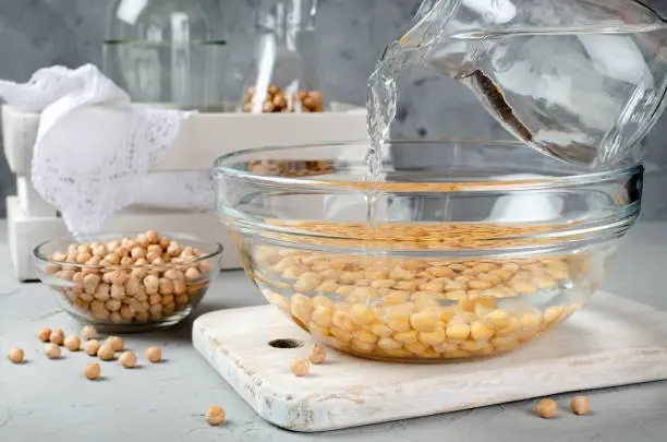 Chickpea soaked in water in a glass bowl. Ingredients for cooking