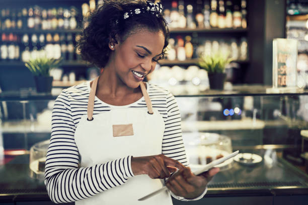 istock Young African entrepeneur standing in her cafe using a tablet 946155898