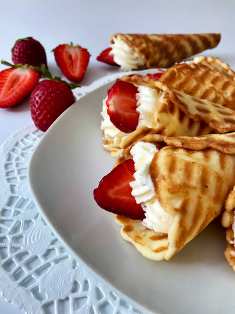 istock Waffle horns with cream, decorated with strawberries. 946156256