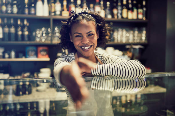 istock Friendly African entrepreneur shaking hands from behind her cafe counter 946159996