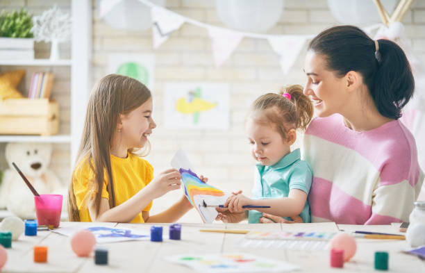 istock Mother and daughters painting together 946165754