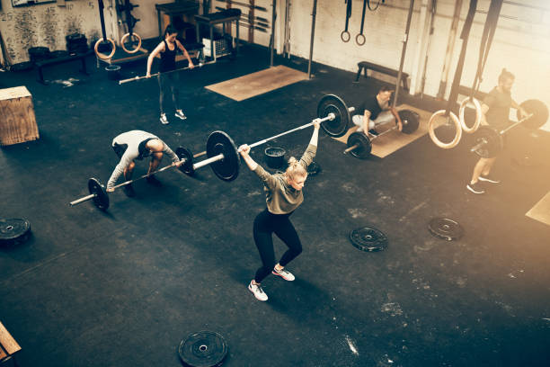 istock Fit people working out with weights together in a gym 946169042
