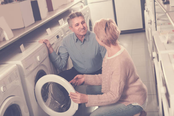 istock Mature smiling couple choosing home washing machine 946170842