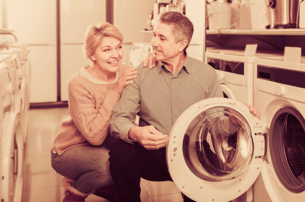 istock Mature couple choosing washing machine in store 946170862